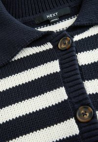 Granatowa i biała, paskowana dzianinowa koszulka polo z kołnierzykiem, z zapięciem na guziki w designie przypominającym muszelki. Teksturowany materiał.