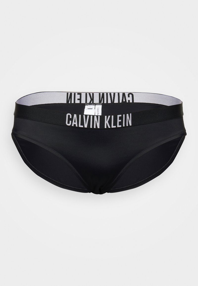 Funda de biquíni preta com um tecido liso e elástico. Apresenta uma cintura larga com "CALVIN KLEIN" impresso em branco. Corte clássico.