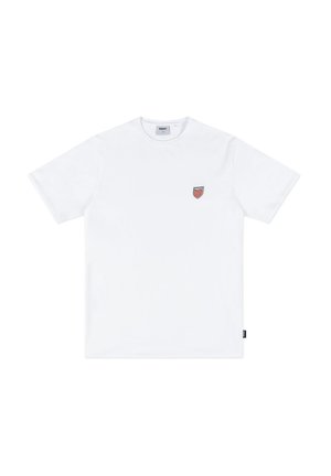 Biała bawełniana koszulka z krótkimi rękawami, okrągłym dekoltem oraz małym czerwonym logo tarczy na lewej piersi. Prosty design, gładka tekstura.