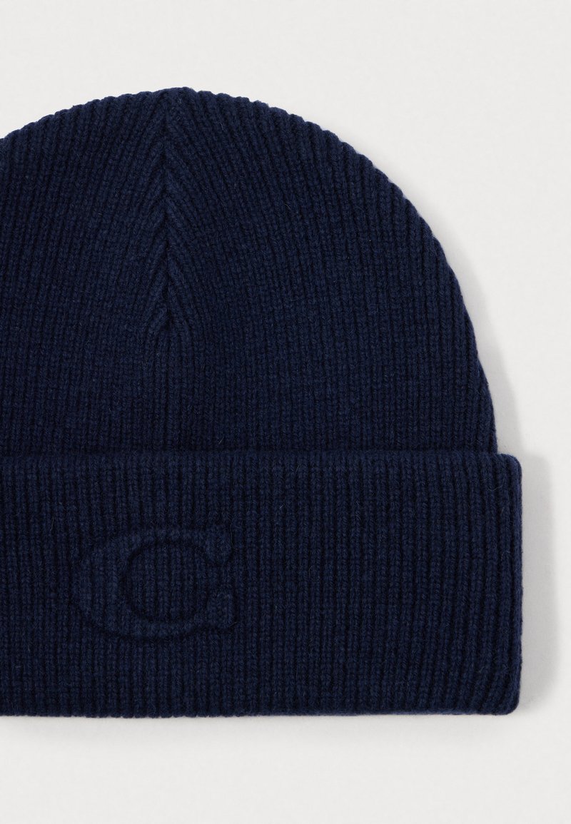 Berretto lavorato a maglia navy con risvolto e logo goffrato discreto, realizzato in un morbido e strutturato misto lana. Vestibilità classica e aderente.