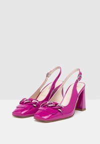 Sandalette in pelle verniciata rosa con punta quadrata larga, caratterizzata da un accento di catena argentata e un tacco a blocco medio.