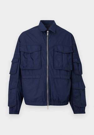 Navy blue zip-up jacket with multiple flap pockets on chest and sleeves, elastic cuffs, and a shirt-style collar.