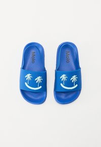 Blå halksandaler i texturerat gummimaterial, med en smiley-ansiktsdesign som har palmträd och ett böjt rand. Märkesnamnet "Molo" inuti.