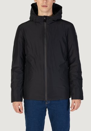 Giacca nera con cappuccio e zip frontale, realizzata in un materiale liscio e idrorepellente, dotata di due tasche laterali con zip. Design semplice e funzionale.