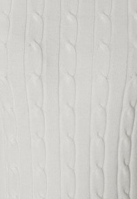 Witte gebreide trui met een textuur kabelpatroon en verticale ribbels, gemaakt van zachte stof, wat zorgt voor een gladde en gezellige uitstraling.