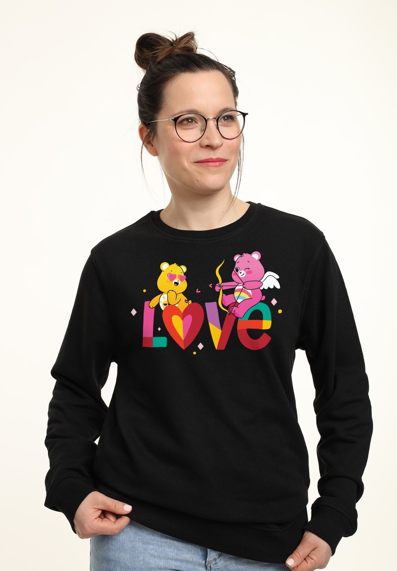 Felpa nera con un design grafico colorato che presenta due orsi stilizzati, cuori e la parola "Amore" in lettere vivaci.