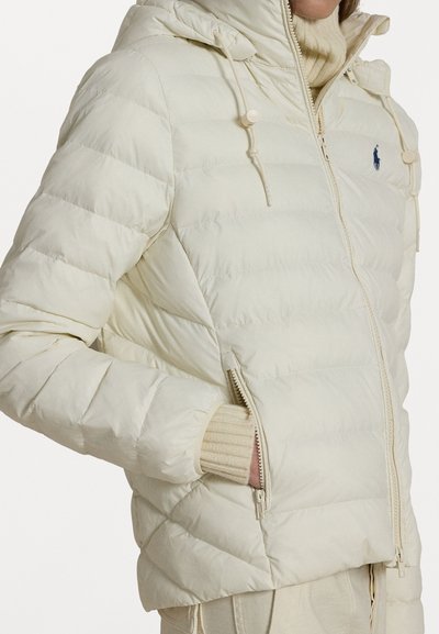 Light cream puffer jacket made of smooth fabric, featuring a hood, zippered pockets, and ribbed cuffs. Notable horizontal quilted pattern.