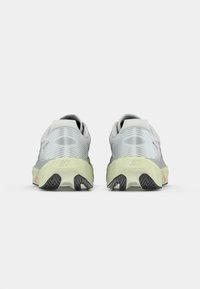 Gray athletic shoes featuring a textured mesh upper, a cushioned light green midsole, and a black rubber outsole with traction pattern.