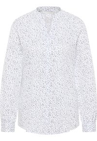 Chemise à manches longues avec boutons, en tissu blanc à motif de points noirs, dotée d'un col montant et de poignets élastiqués pour une coupe décontractée.