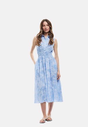 Vestido de algodón azul claro con cuello tipo polo abotonado, cintura fruncida y patrón floral; hasta la rodilla con un ajuste relajado.