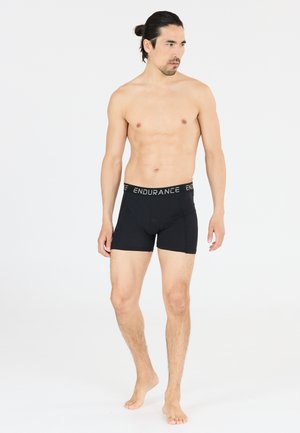 Zwarte katoenen boxershorts met een gestructureerde elastische tailleband met de tekst "ENDURANCE" in het grijs. De pasvorm is strak met een lengte tot halverwege de dij.