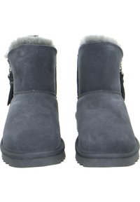 Graue Wildleder-Stiefeletten mit einem weichen Fellfutter, flachen Gummisohlen und einem seitlichen Reißverschluss für ein einfaches Anziehen.