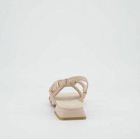 Sandalo in pelle nudo con cinghie incrociate, soletta imbottita e tacco a blocco basso. Presenta un dettaglio con fibbia dorata e una texture liscia.