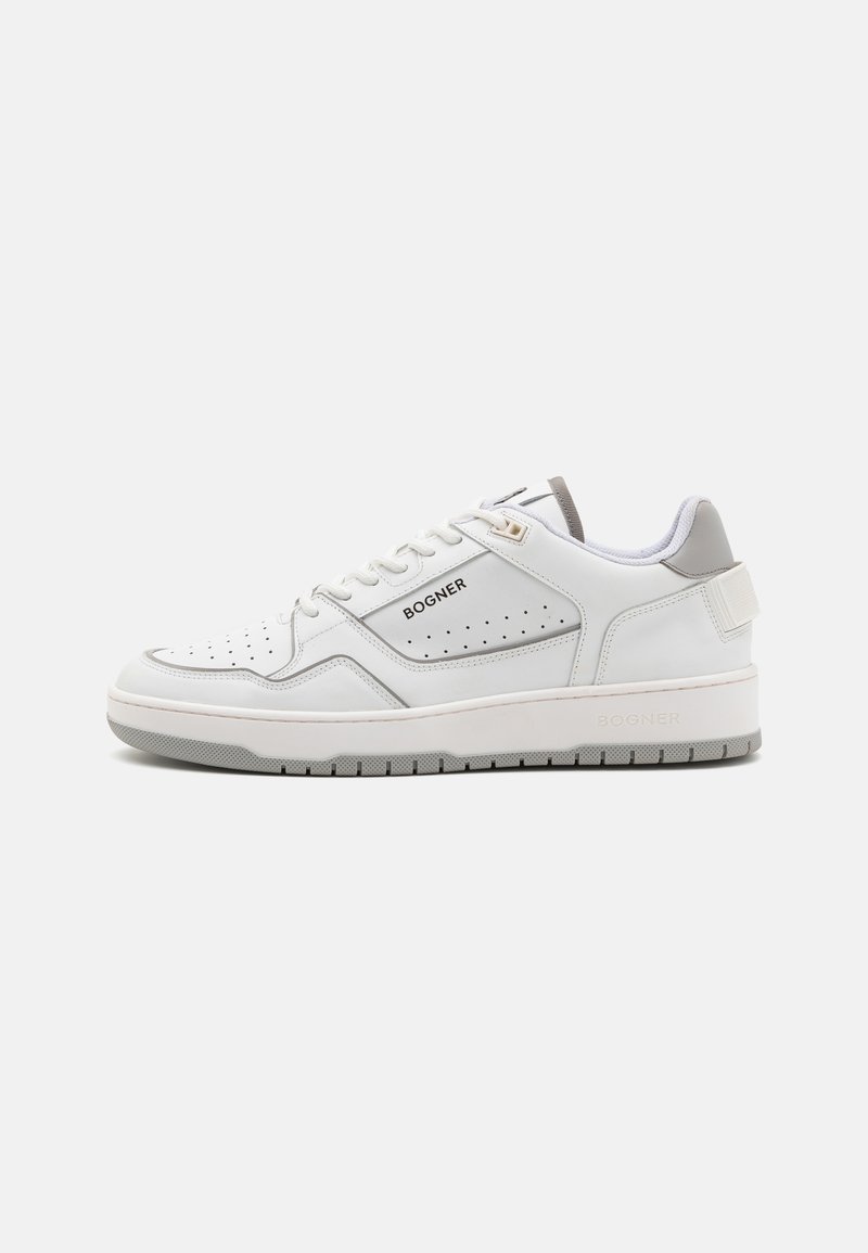 White leather sneaker with perforated sides, grey accents, and flat rubber sole. Features laces and brand logo on the side and heel.