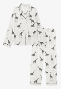 Biały zestaw piżamowy wykonany z gładkiego materiału, z powtarzającym się czarnym wzorem żyrafy, z czarnymi obszyciami na kołnierzyku i nogawkach.