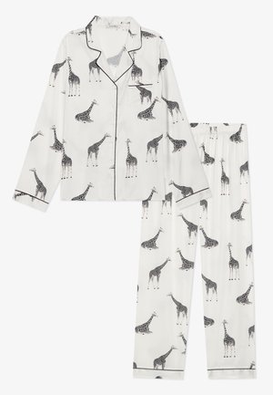 Hvit pyjamassett laget av glatt stoff med et gjentatt svart giraftrykk, med sort piping-detaljer på kragen og buksene.