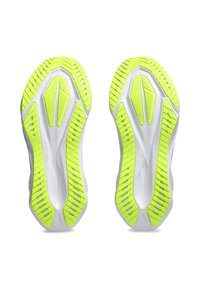 Semelles de chaussures blanches avec des accents en caoutchouc jaune vif. Présente un motif de traction texturé et un design épuré pour la performance.