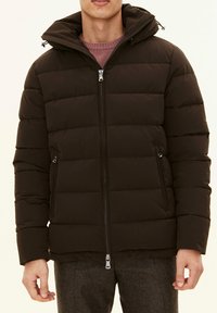 Donkerbruine pufferjack met een ritssluiting aan de voorkant, afneembare capuchon, gequilt ontwerp en zijzakken. Gladde textuur, verstelbare trekkoorden voor de capuchon.