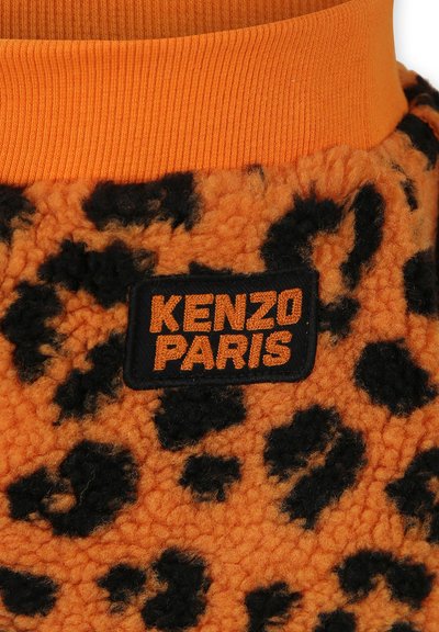 Vêtement en polaire orange avec un imprimé léopard noir, doté d'un col en rib à rayures orange et d'une étiquette tissée noire avec "KENZO PARIS" en orange.