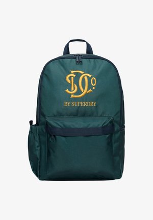 Dunkelgrüner Rucksack mit Frontreißverschlusstasche und goldbesticktem "JD Co BY SUPERDRY"-Logo, mit gepolstertem Griff und seitlichem Flaschenhalter.