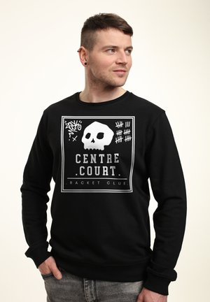 Felpa nera in cotone, con una grafica di teschio bianco e il testo "CENTRE COURT RACKET CLUB" in un design rettangolare.