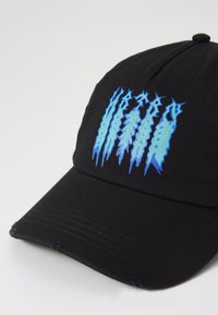 Black cap with a curved brim, featuring blue graphic embroidery resembling scratches on the front. Made from woven fabric with a textured finish.