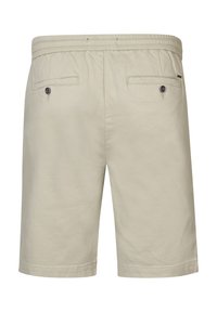 Beige katoenen shorts met een elastische tailleband, voorzien van twee achterzakken met knoopsluitingen en een rechte pasvorm. Soepele textuur.