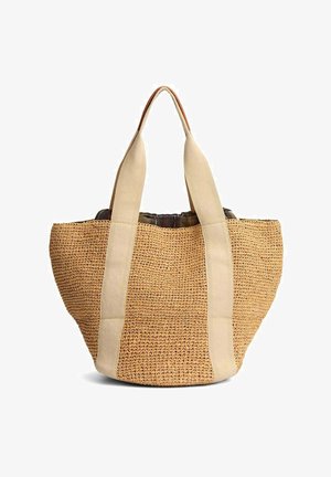 Sac cabas en paille tressée avec de larges anses en tissu beige qui descendent sur les côtés, ouverture en haut et une structure souple et flexible.