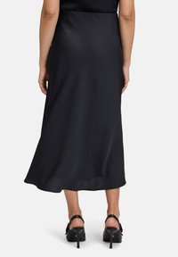 Schwarzer Satin-Midi-Rock mit fließender Silhouette, glatter Textur und leichtem Glanz; zeigt eine figurbetonte Taille und einen ausgestellt geschnittenen Saum.