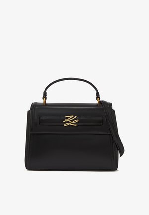 Černá kožená kabelka s vrchním uchopem, nastavitelným ramenním popruhem a zlatým dekorativním logem na předním klopě.