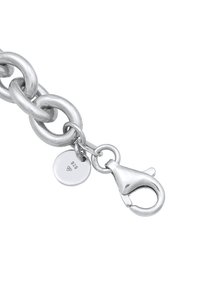 Sølv metal kædearmbånd med store polerede led, en krabbe-lås og et rundt mærke præget med "925" for silvers indhold.