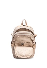 Béžový batoh s několika otevřenými kapsami na zip, polstrovanými vnitřními kapsami a nastavitelnými bočními popruhy na bílém pozadí.