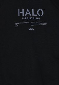 T-shirt in cotone nero con testo bianco. I dettagli principali includono "HALO," "1968 1972 1981," e "ATW" con sottili variazioni nel peso del carattere.