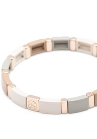 Bracelet élastique composé de segments rectangulaires dans des teintes de gris doux, blanc et beige, entrecoupés de accents brillants en or rose.