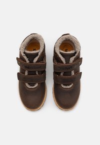 Bottines en cuir marron avec doublure douce grise, dotées de deux bandes réglables en Velcro et d'une semelle en caoutchouc légère.