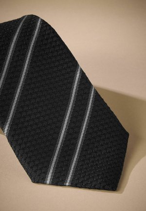 Pajarita negra con un patrón texturizado que presenta tres rayas diagonales grises. La tela parece estar tejida con un ligero brillo.