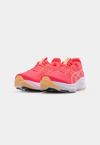 Bright pink running shoes with a smooth texture, featuring a cushioned sole, white midsole, and light tan outsole. Minimalist design and lacing.