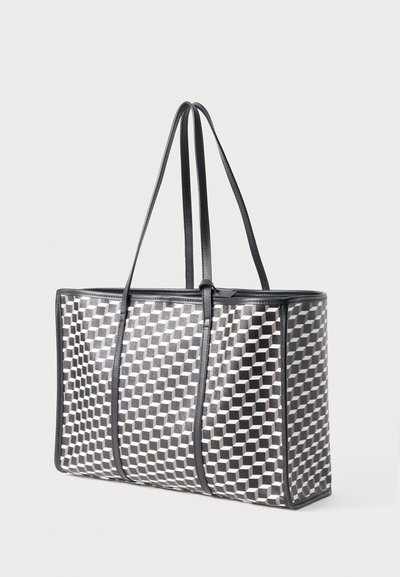 Sort-hvid geometrisk mønster tote bag med to lange håndtag, struktureret form og glat overflade. Forstærkede kanter med sort trim.