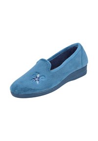 Zapatilla de tela azul con textura suave, punta redondeada y un pequeño diseño floral bordado en púrpura y blanco. Tacón resistente y suela flexible.