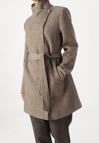 Manteau long marron texturé avec un col montant et une taille nouée, doté de deux poches latérales et d'une coupe ajustée.