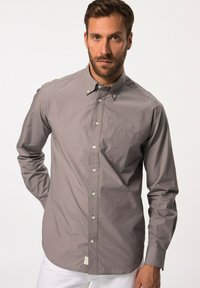 Chemise grise à boutons en tissu léger, dotée d'une poche poitrine, d'un col pointu et de manches longues, avec un ourlet arrondi et un subtil éclat.