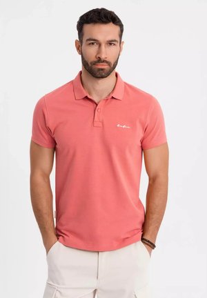 Polo de manga corta color coral con tapeta de dos botones, sutil bordado del logo en el pecho y una mezcla de algodón.