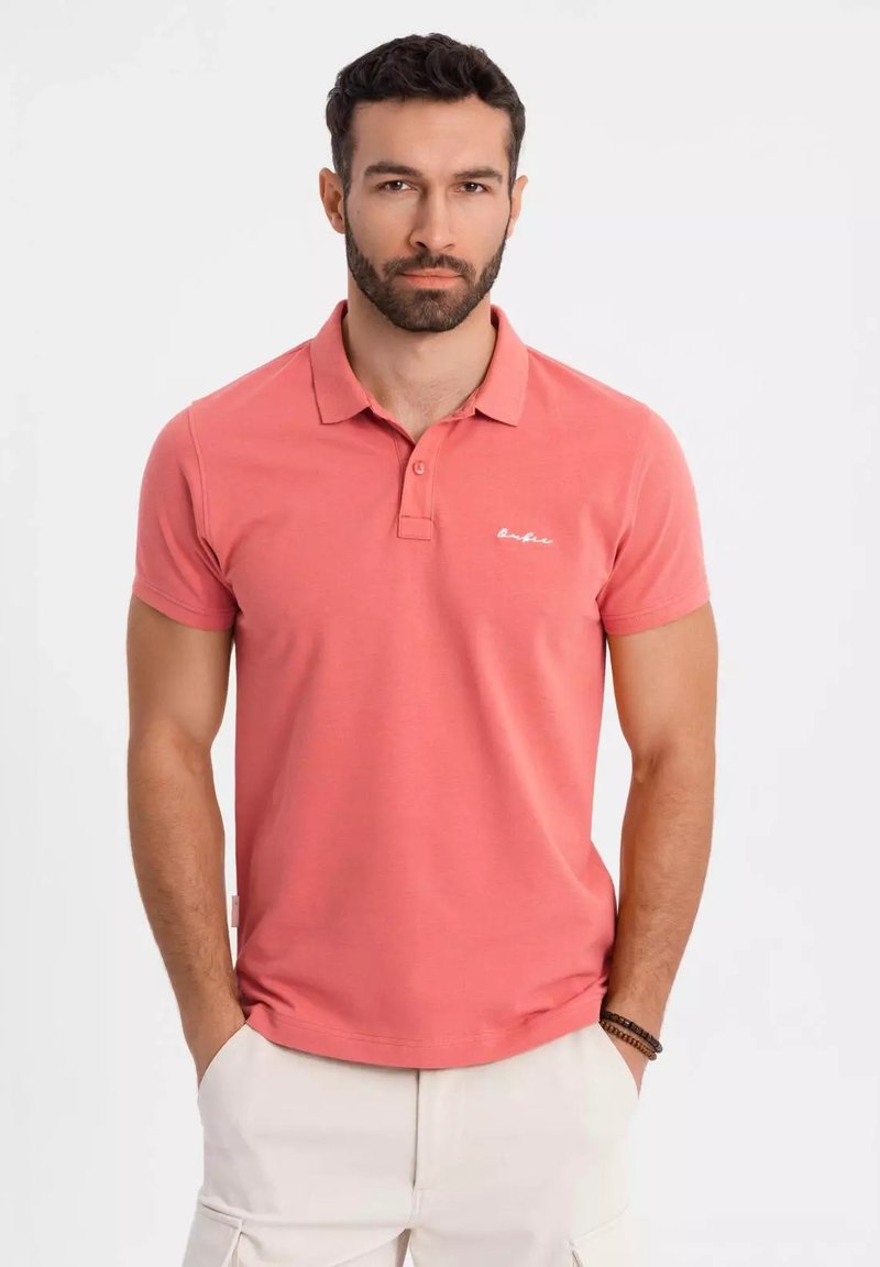 Lyhythihainen korallinvärinen polo paita, jossa on kaksinappinen kaulus, huomaamaton logo-embroidointi rinnassa ja puuvillasekoitekangas.