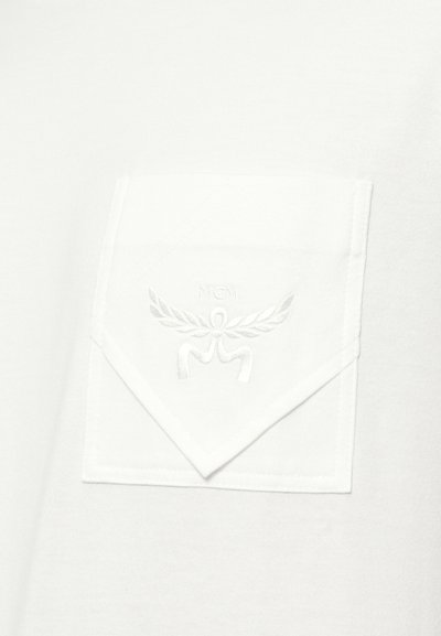 White fabric with a white rectangular pocket featuring a pointed flap and embossed MCM logo with laurel wreath design.