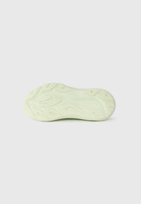 Shoe outsole in light green with textured patterns and grooves for traction, featuring an abstract design and smooth edges.