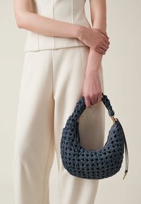 Knitted dark blue handbag with a textured surface and woven design, featuring a curved handle and gold hardware accents.
