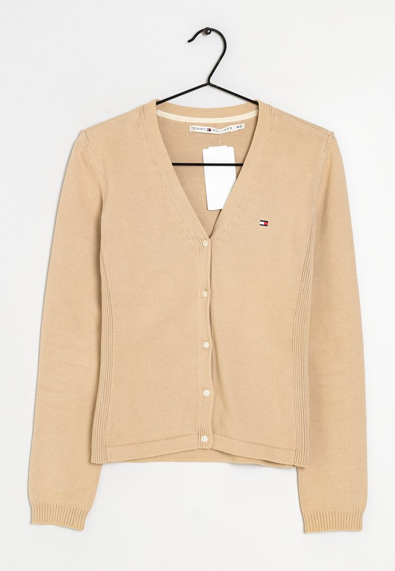 Cardigan en tricot beige avec un col en V, des manches longues et des boutons sur le devant. Présente un petit logo sur la poitrine gauche. Tissu texturé.