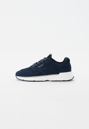 Navy knit sneakers with a textured upper, white sole, and accent detailing. Features round laces and a padded collar for comfort.