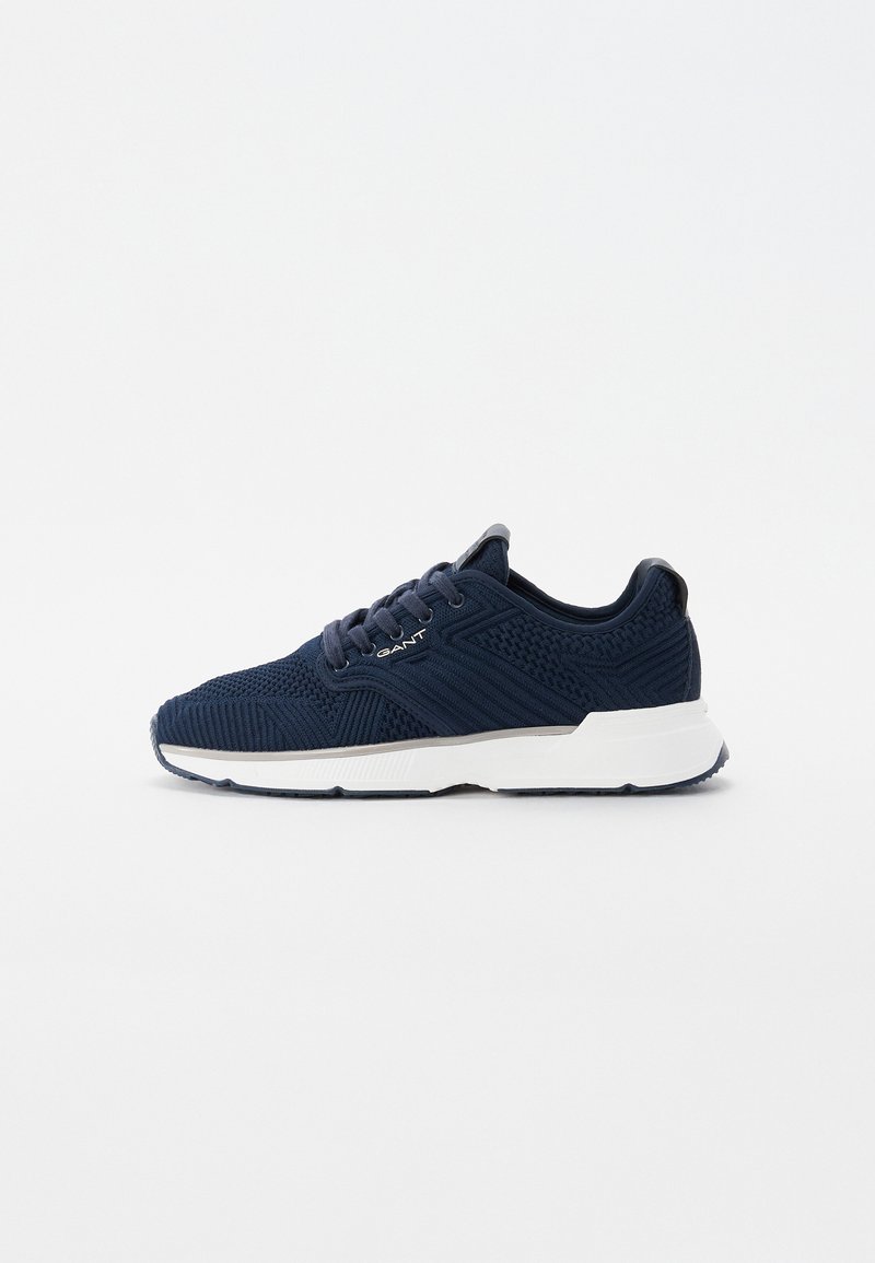 Marineblå strikkesneakers med teksturert overdel, hvit såle og detaljer i kontrast. Har runde snørebånd og polstret krage for ekstra komfort.