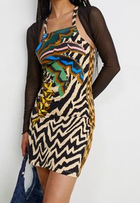 Multicolored, fitted dress with animal print and zigzag pattern. Material appears stretchy, with thin shoulder straps and side accents.